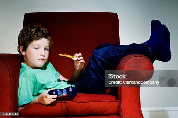 Foto de Entediado Couch Potato Menino Comer Junk Food e mais fotos de stock de Alimentação Não-saudável - Alimentação Não-saudável, Assistindo, Brand Name Video Game