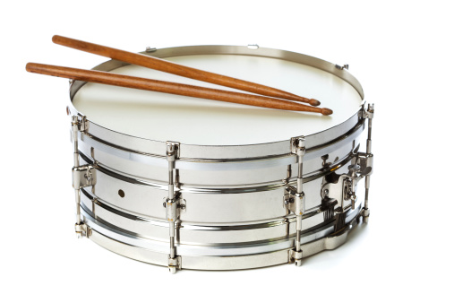 Subject: A silver chrome snare drum with drum sticks isolated on a white background.