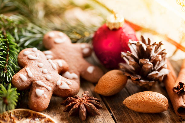 gingerbread man cookies, golden baubel and pine branch, christmas lights in background, 