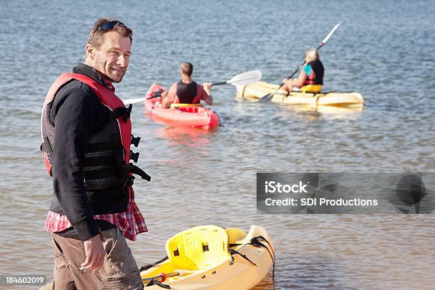 Man Looking Back Before Heading Out To Kayak With Friends Stock Photo - Download Image Now