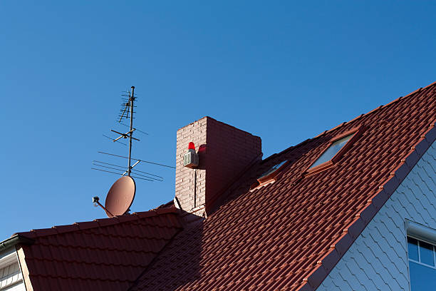 Satellite dish mounted on the roof "roof with satellite dish, antennaand alarm system with blue sky" animal antenna stock pictures, royalty-free photos & images
