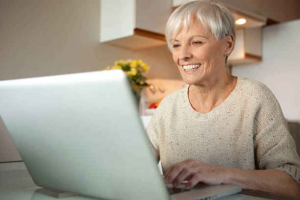 istock Senior Lady With Laptop In The Kitchen 184602364