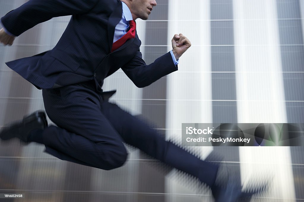 Uomo d'affari saltando con velocità in metallo lucido Office Building - Foto stock royalty-free di Businessman