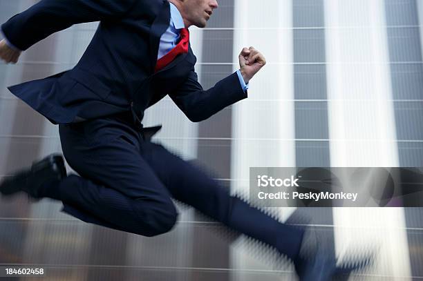 Uomo Daffari Saltando Con Velocità In Metallo Lucido Office Building - Fotografie stock e altre immagini di Businessman