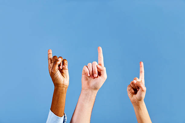 istock Three mixed hands point excitedly up into the blue 184602960
