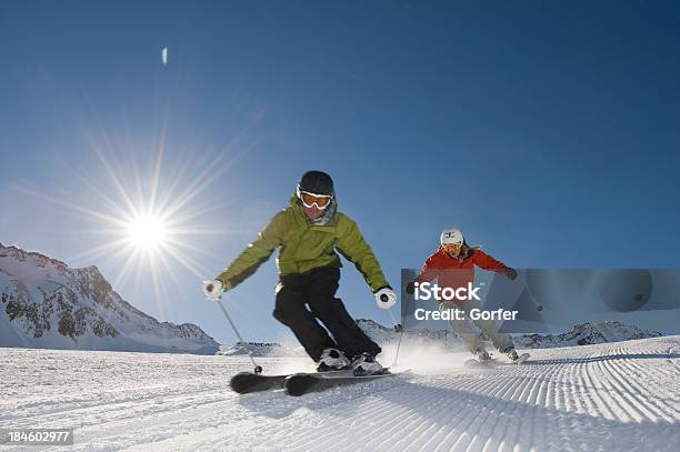 Skier In Action With The Sun Behind Stock Photo - Download Image Now - Skiing, Friendship, Close-up