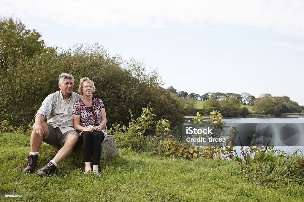 Mature couple enjoying autumn walk alongside lake 50-54 Years Stock Photo