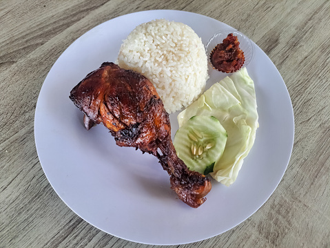 Delicious Grilled Chicken With Rice (Nasi Ayam Bakar), Cabbage, Cucumber Sliced And Spicy On A Plate. Food Menu.