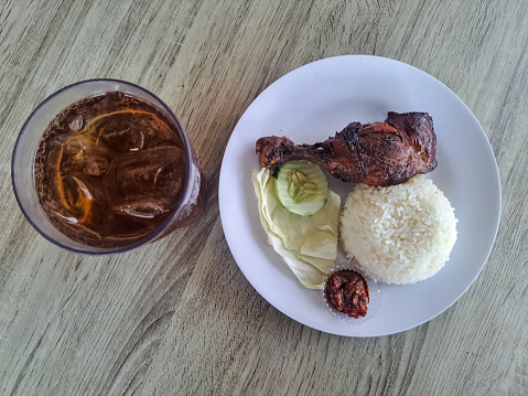 Serving Food Of Grilled Chicken With Rice, Spicy Sauce And Tea Iced. Food And Drink Menu. Nasi Ayam Bakar Dengan Sambal Dan Minuman Es Teh. Top View