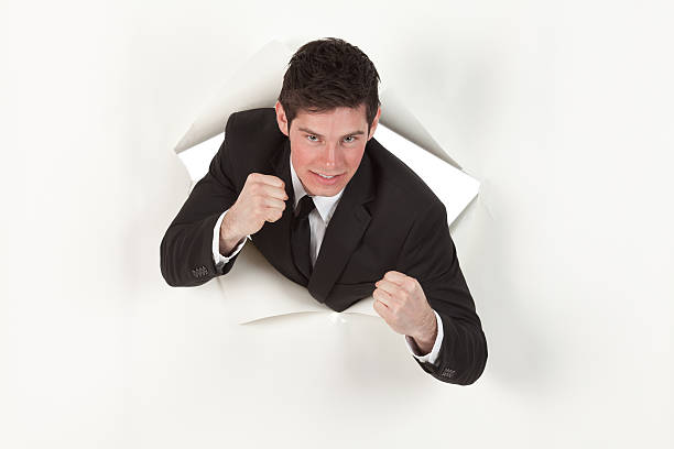 istock Businessman emerging through from hole of paper 184604508