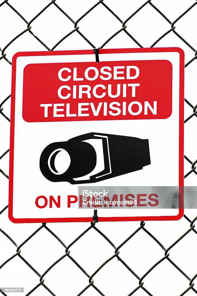 Video Surveillance In Use Sign Video surveillance sign attached to a chain link fence surrounding a high security industrial facility. Shallow dof with focus on sign. Big Brother - Orwellian Concept Stock Photo