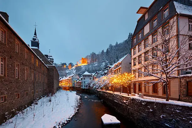 The river Rur in the German Eifel village of Monschau during christmas time at night.