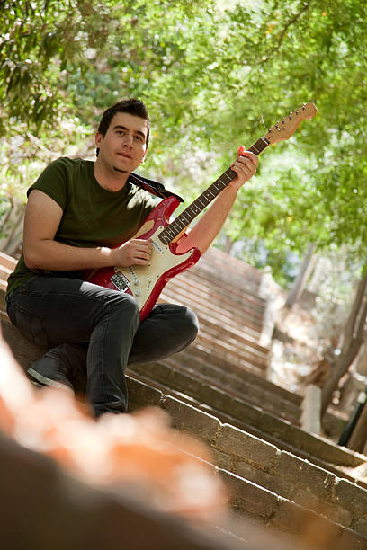 giovane musicista maschio con una chitarra elettrica su scala - rock staircases foto e immagini stock