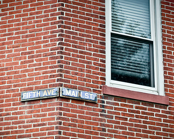 Street Sign Street sign oddly located on the corner of a brick house street name sign stock pictures, royalty-free photos & images