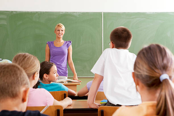 istock Female Teacher Questioning little students 184605675