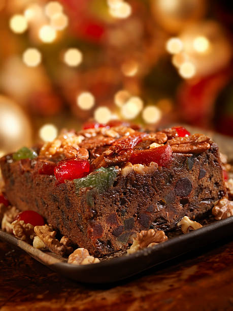 Fruit Cake at Christmas Fruit Cake by the Christmas Tree and Fireplace -Photographed on Hasselblad H3D2-39mb Camera fruitcake stock pictures, royalty-free photos & images