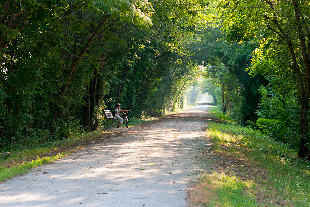 ruta por el túnel de árboles, chica con bicicleta - natural tunnel state park fotografías e imágenes de stock