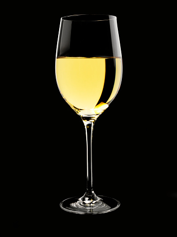 A simple glass of white wine with copy space. Isolated on black.Click on the link below to see more of my wine and drink images.
