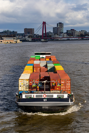 Rotterdam, Netherlands, Nov 11, 2023 A container barge motors under the Erasmus Bridge in the Rotterdam habour.