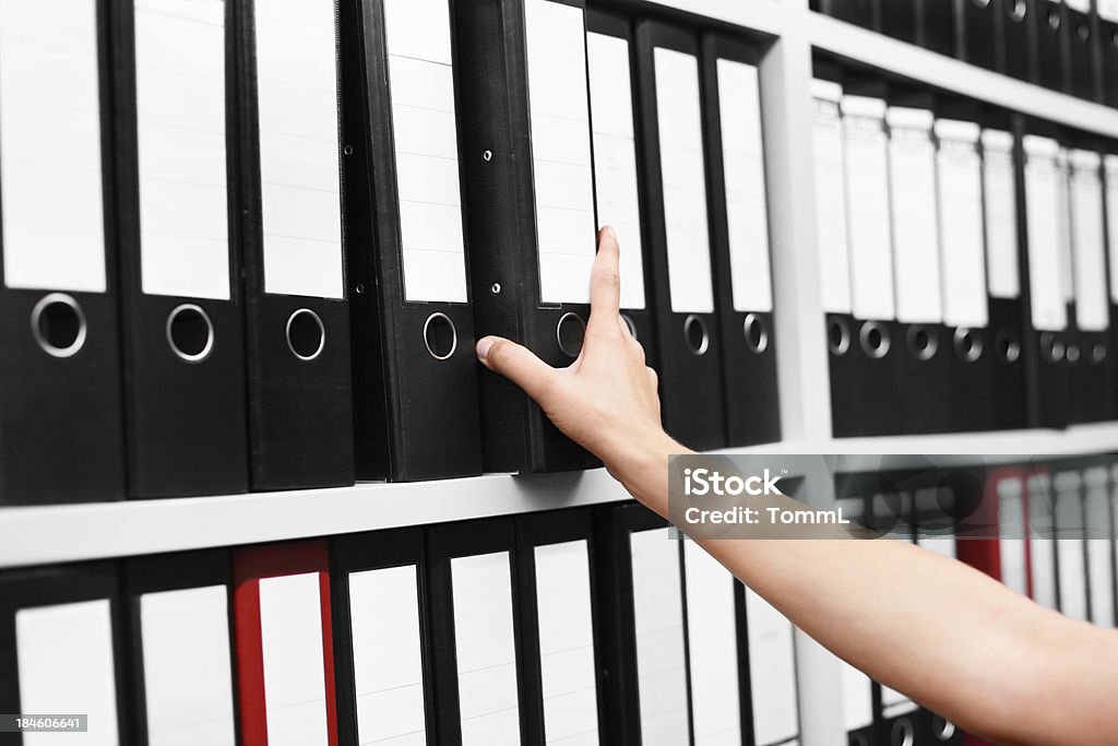 Filing Folders in Archive Hands of a person filing a folder in an archive room. Adult Stock Photo