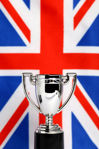 England vs. Wales two flags on flagpoles and blue cloudy sky background.Soccer matchday template