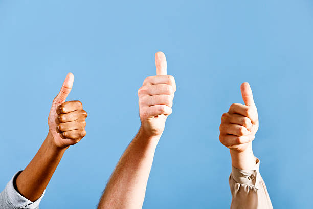 istock Three hands making thumbs-up sign against blue sky 184607203