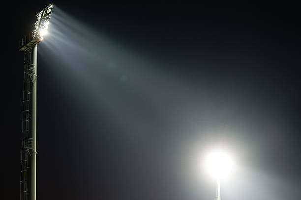 istock Two stadium lights at night with bright light beams 184607460