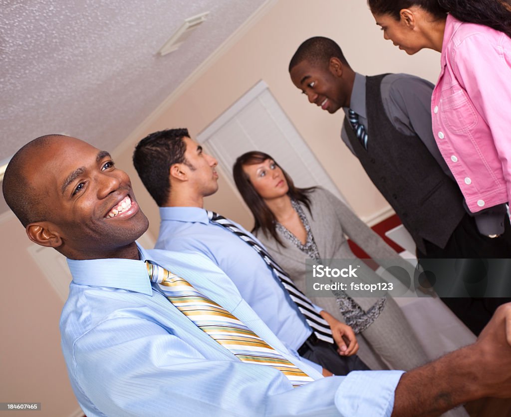 Adulto joven estrechándose las manos en una reunión de negocios. - Foto de stock de 20 a 29 años libre de derechos