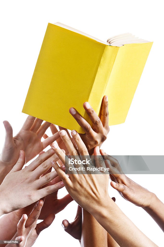 Wiele ręce chwytając w yellow book. Na białym tle. - Zbiór zdjęć royalty-free (Aspiracje)