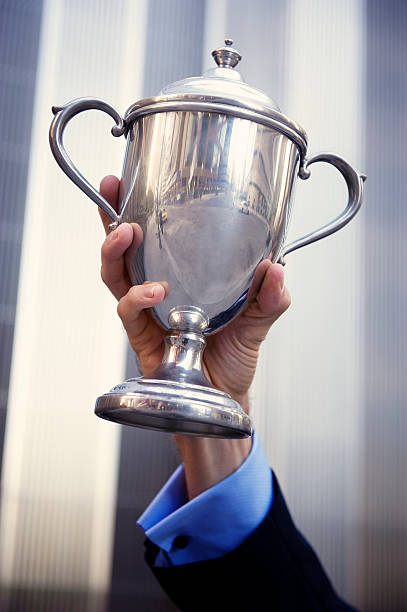 istock Hand of Businessman Holds Silver Trophy 184607498