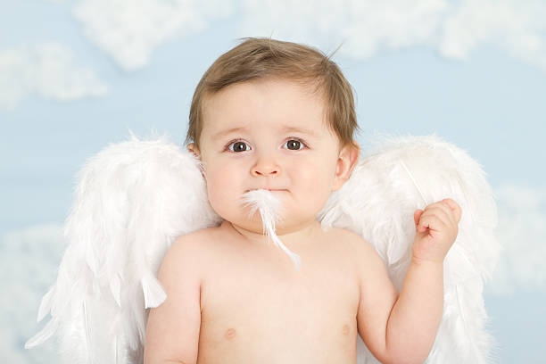 istock Beautiful angel boy eating a feather 184608090
