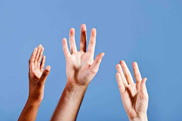 istock Three hands reach up longingly towards sky blue background 184608147