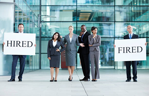 istock Business people holding 'hired' and 'fired' boards 184608281