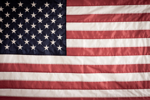 Color image of an American flag. Some desaturation and grain added for vintage feel.