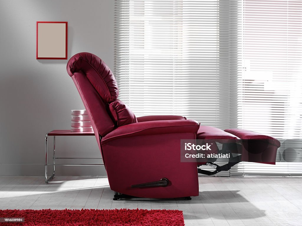 A red lounge chair in a living room burgundy tv chair Reclining Chair Stock Photo