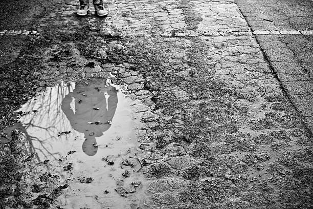 Shadow of man on a puddle