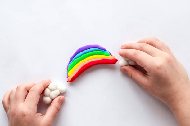 istock The child sculpts a rainbow and clouds from plasticine. Children's creativity. 1846098381