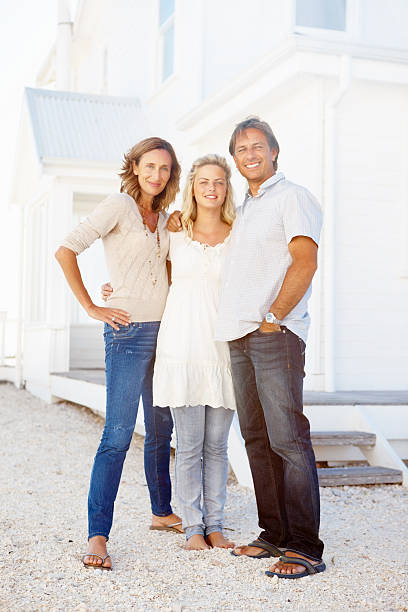 istock Family of three standing outside home 184609980