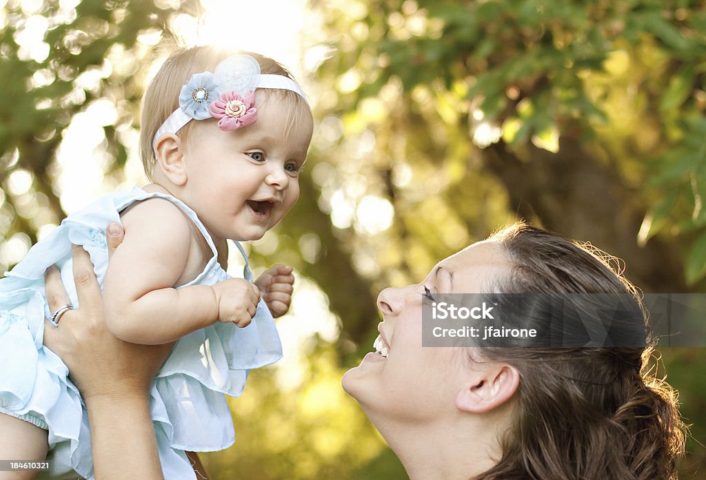 Bambino e mamma all'aperto con luce calda - Foto stock royalty-free di Accudire