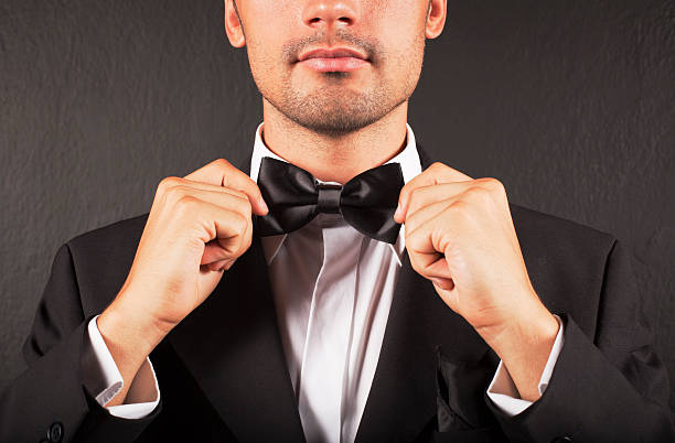 istock A man in a suit tying his bow tie 184610328