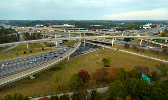 American freeway intersection with fast driving cars and trucks. View from above of USA transportation infrastructure.