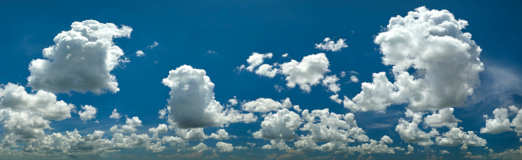 White puffy cumulus clouds on summer blue sky.