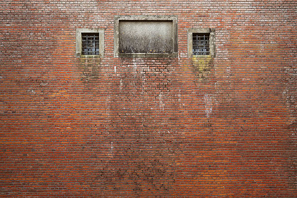 alte gefängnis wall - brick wall old window brick stock-fotos und bilder