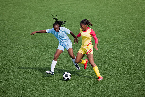 Womens Soccer Two women soccer players compete for the ball womens soccer stock pictures, royalty-free photos & images