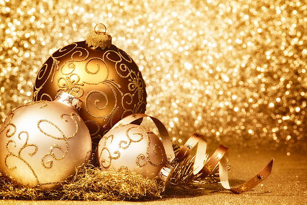 Golden Christmas decoration with Christmas baubles on glittery background