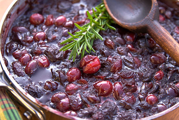 Cranberry sauce cooking for Christmas or Thanksgiving Cooking holiday dinner cranberry sauce: Fresh rosemary & cranberries. (SEE LIGHTBOXES BELOW for more Thanksigivng, Christmas cooking & food backgrounds...) compote stock pictures, royalty-free photos & images