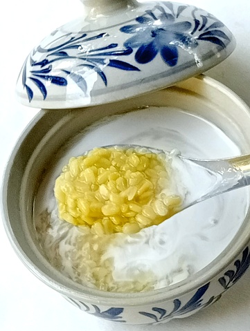 Tao suan topped with coconut milk is a Thai dessert. Tao suan make from split green bean seeds. Close -up shot of the dessert.