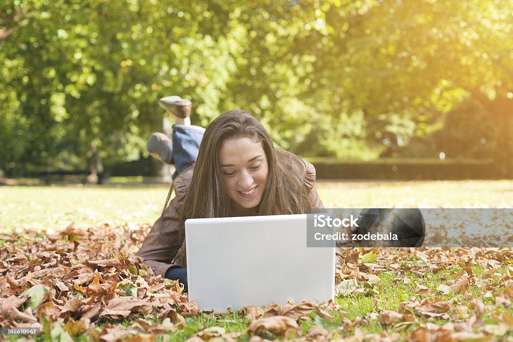 Junge lächelnde Frau mit Laptop im Park - Lizenzfrei Akademisches Lernen Stock-Foto