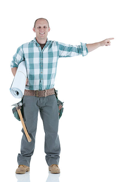 istock Carpenter carrying bluprints and pointing sideways 184610995