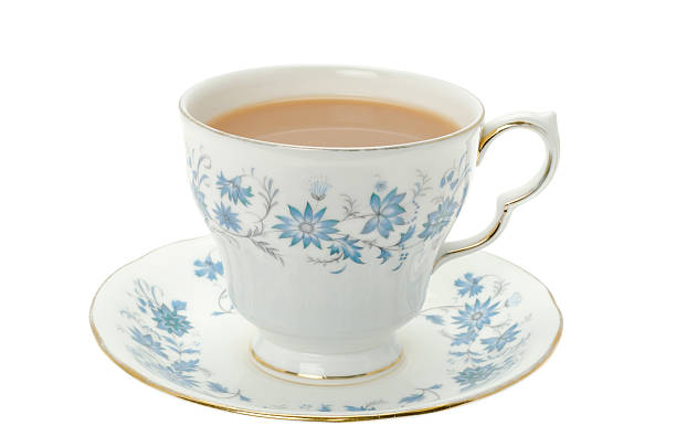 Hot tea served in a bone china cup and saucer A cup of hot tea served in an ornate blue patterned bone china cup and saucer - studio shot. tea cup and saucer stock pictures, royalty-free photos & images